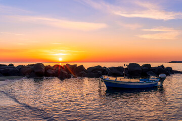 nice old vintage boat on a sea coast with picturesque view on a sunrise in a rocky gulf