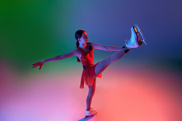 Winter sports. One junior female figure skater in red stage costume showing base figure skating elements, movements isolated over gradient green-blue background in neon light.