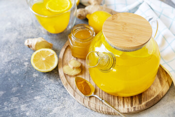 Healthy organic vegan drink. Antioxidant ginger turmeric lemon tea with honey on a stone table. Winter tea, Immunity boosting drink. Copy space.