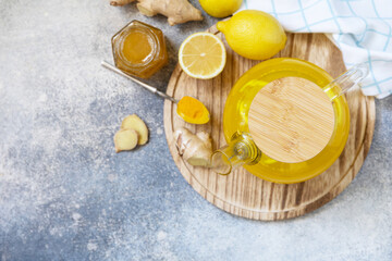 Healthy organic vegan drink. Antioxidant ginger turmeric lemon tea with honey on a stone table. Winter tea, Immunity boosting drink. View from above. Copy space.