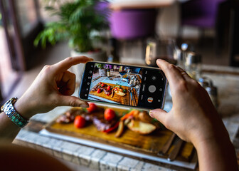 Person takes a photo of food.