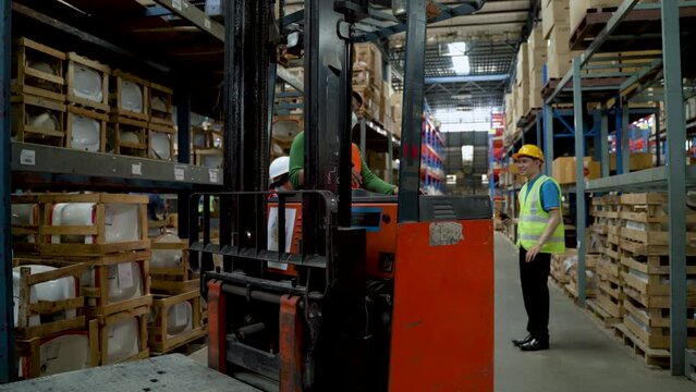 4K, Forklift drivers are driving along racks in warehouses preparing to find products delivery to customers. colleagues to advise and watch out for accidents nearby and everyone wears a safety shirt.