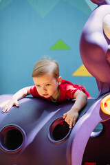 Obraz premium Happy laughing boy 1-2 years old having fun in ball pit in kids amusement park and indoor play center. Activity toys for little kid