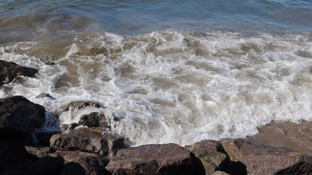 Waves in the sea crashing with breakwaters on the beach
