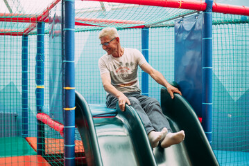 Happy laughing boy 1-2 years old having fun in ball pit  in kids amusement park and indoor play...