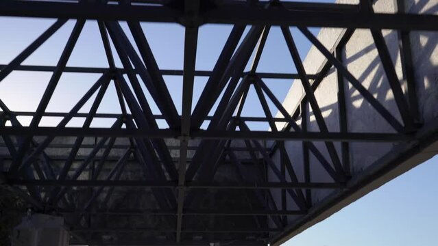 The camera tilts down revealing the park at the Los Angeles County Museum of Art (LACMA) during sunset with buildings and infrastructure in the background on a sunny California day.