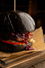 Black burger with beef, cheese and lingonberry sauce