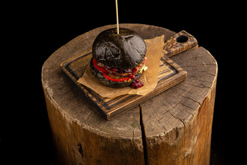 Black burger with beef, cheese and lingonberry sauce