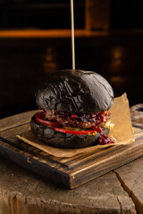 Black burger with beef, cheese and lingonberry sauce