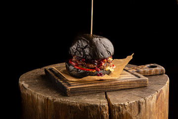 Black burger with beef, cheese and lingonberry sauce