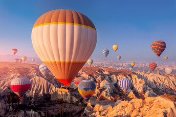 Amazing sunrise landscape in Cappadocia with colorful hot air balloon fly in sky over deep canyons, valleys. Turkey banner travel Concept