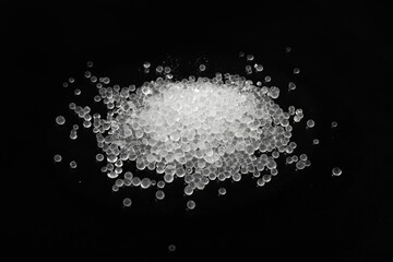 Obraz na płótnie Canvas Desiccant Silica Gel Adsorbent Crystals on Black Background, Desiccant Polymer Balls