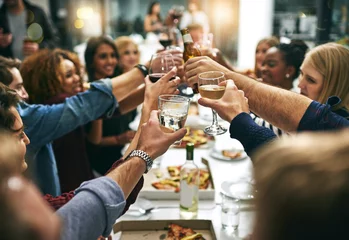 Foto op Plexiglas Diner, toast en vrienden in een restaurant voor feestvieren, sociale bijeenkomsten en oudejaarsavond. Alcohol, kerstfeest en groep mannen en vrouwen proost op etentje met cocktails © Mikolette M/peopleimages.com