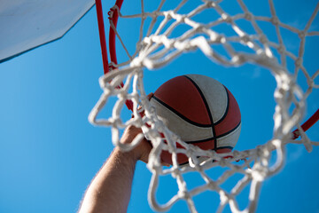 Hands and basketball. Scoring the winning points at a basketball game. Basketball as a sports and fitness symbol of a team leisure activity playing outdoor.