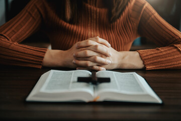 Woman praying on holy bible in the morning.Woman hand with Bible praying. Christian life crisis prayer