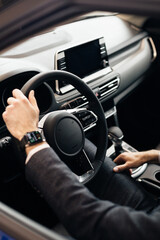 Close up of steering wheel in male driver hand, copy space. Man's hand holding steering wheel...
