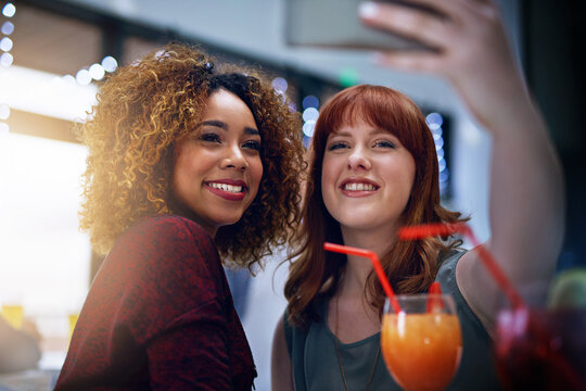 Phone, selfie and friends with club cocktail for happy hour, wellness and bonding. Interracial, women and friendship gathering with smartphone photograph and alcohol drinks with smile.