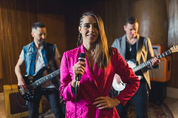 Obraz premium A woman singer with two man accompanying her on the guitars. High quality photo