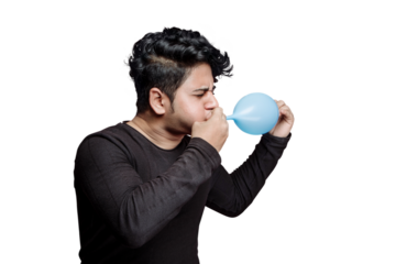 Young man blowing air balloon orally inflating with mouth, blowing hard with mouth creating air pressure. Copy space, event preparation or oral lungs exercise