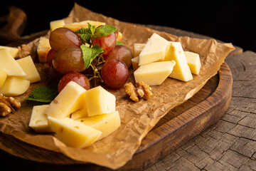 Cheese plate garnished with grapes and walnuts