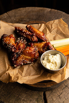 Chicken wings in teriyaki sauce with sticks of carrots, celery with sour cream sauce