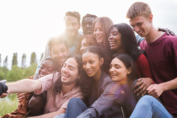 Group of young friends from different cultures taking a selfie outdoors after a fun afternoon