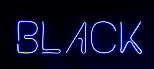  isolated on black wall. Black tattoo - neon sign on dark wall background.