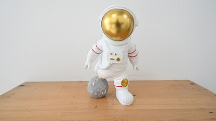Plastic figure of an astronaut in a spacesuit. Toy minifigures on wooden table