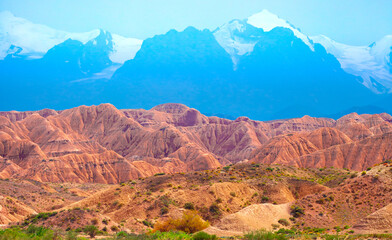 Naklejka premium Natural unusual landscape of red rocks against the backdrop of blue mountains. The extraordinary beauty of nature is similar to the Martian landscape. Amazingly beautiful landscape.