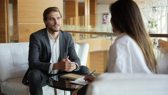 Businessman giving businesswoman some very important advice. Two well dressed businesspeople having a serious discussion in their corporate office. Two employees, workmates discuss new project
