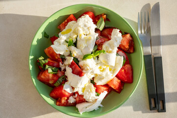 Itaian vegetarian food, fresh caprese salad made with white soft italian mozzarella cheese, red tomato and green basil