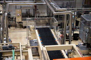 Production of cremant sparkling wine in Burgundy, France. Automatically powered bottling lines on factory.
