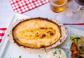 Quenelle, speciality of Lyon, oval-shaped dumplings filled with pike white fish served in creamy sauce in traditional Lyonnaise Bouchon, France