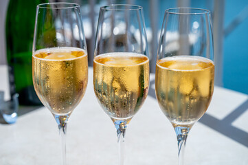 Drinking of French brut champagne sparkling wine in glasses in yacht harbour of Port Grimaud near Saint-Tropez, French Riviera vacation, France