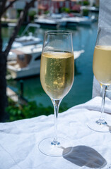 Drinking of French brut champagne sparkling wine in glasses in yacht harbour of Port Grimaud near Saint-Tropez, French Riviera vacation, France