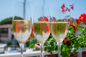 Drinking of French brut champagne sparkling wine in glasses in yacht harbour of Port Grimaud near Saint-Tropez, French Riviera vacation, France