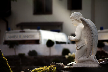 Statue of a praying Angel as a symbol of faith, and hope, near the ambulance van.