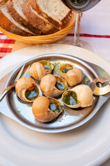 Starter dish in traditional restaurants on Burgundy, snails cooked with butter, garlic and herbs
