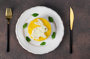 Puff salad Mimosa for the New Year 2023 with canned tuna, potatoes and carrots, decorated bunny from egg, Top view