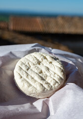 One small fresh white cheese  made in Provence from unpasteurised goat milk