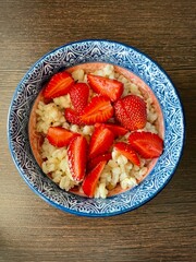 vertical photo. farm vegetables. barley porridge with fresh strawberries. diet food. healthy lifestyle. healthy cereals. eco. bio.