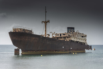 The Telamon shipwreck on the sea under a cloudy sky in Lanzarote Island , Spain