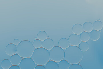 Oil and water bubbles pattern on blue gradient idea for face serum or skin care background. Art image pattern.