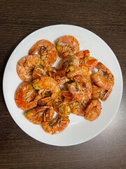 large vertical photo. view from above. many large langoustines on a white plate. grill. beautiful wholesome food. eco. bio. fried big shrimp with garlic.