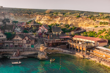 Mellieha, Malta, 21 May 2022:  Sunset over the Popeye Village and its crystal clear water