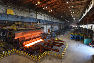 Fototapeta na wymiar machine with conveyor belt with glowing metal frame in the production line of a steel mill