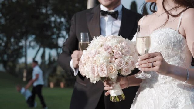 Amazing Married Couple Taking Sincere Congrats From Invited Guests On Banquet Party, Newlyweds Holding Crystal Glass With Refreshing Champagne Or Wine, Aesthetic Medium Shot Of Wedding Couple On