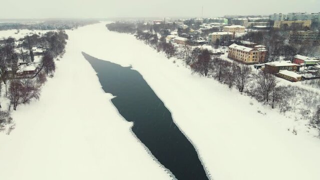 Bird's eye view of a frozen river with a thawed middle. Central Russia. Fabulous winter natural landscape, background, screensaver, footage, video. UHD 4K.
