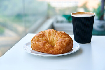 Breakfast in the morning. Croissant and a cup of coffee