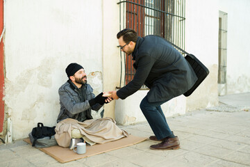 Hungry poor man receiving food from a caucasian man